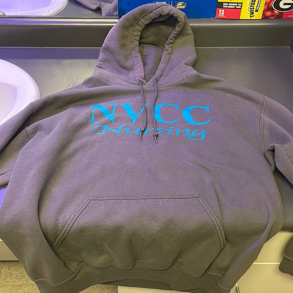 A medium grey hoodie with a nursing logo on it